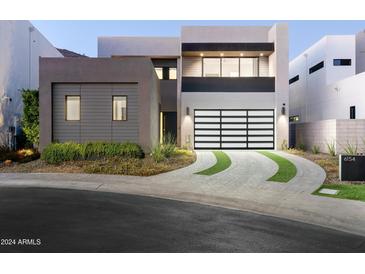 Modern house exterior with a glass-paneled garage door and landscaped driveway at 6154 E Alta Hacienda Dr, Scottsdale, AZ 85251