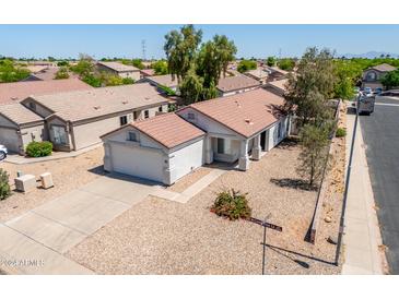 An aerial shot of a single-story house with a driveway and surrounding landscape at 11343 W Mccaslin Rose Ln, Surprise, AZ 85378