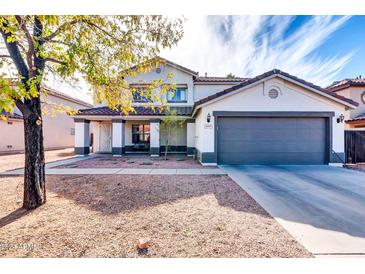 Two-story house with gray garage door and desert landscaping at 10847 E Forge Cir, Mesa, AZ 85208