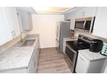 Modern kitchen with granite countertops and stainless steel appliances at 3119 W Cochise Dr # 106, Phoenix, AZ 85051