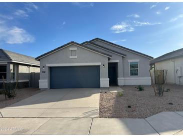 Modern single-story home with a two-car garage and desert landscaping at 38075 W Excussare Way, Maricopa, AZ 85138