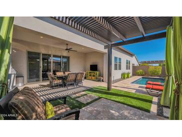 Outdoor oasis with a pergola, pool, and patio dining area at 17209 W Wildwood St, Surprise, AZ 85388