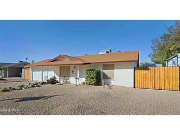 Ranch style home with two car garage and wood fence at 2544 E Hillery Dr, Phoenix, AZ 85032