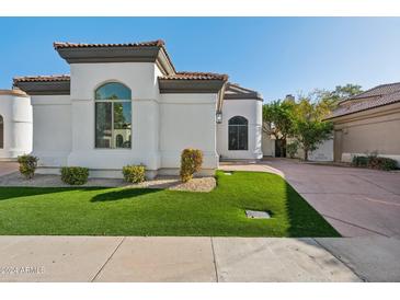 White stucco home with landscaped lawn and driveway at 8133 E Cortez Dr, Scottsdale, AZ 85260
