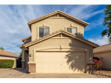 Two-story house with a beige exterior, two-car garage, and landscaping at 8652 E Nido Ave, Mesa, AZ 85209