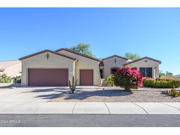 Two-car garage, desert landscaping, and neutral color scheme at 19803 N Desert Song Ct, Surprise, AZ 85374