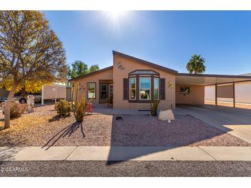 Single-wide manufactured home with covered carport and well-maintained landscaping at 8500 E Southern Ave # 575, Mesa, AZ 85209