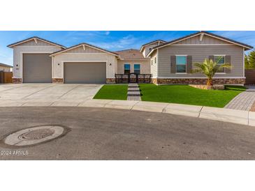 Modern home exterior with a three-car garage and artificial turf at 5170 N 186Th Dr, Litchfield Park, AZ 85340