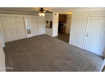 Living room with carpet, mirrored closet doors and access to patio at 3500 N Hayden Rd # 1903, Scottsdale, AZ 85251