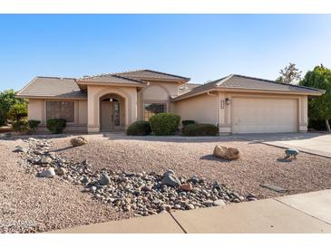 Single story house with a two-car garage and desert landscaping at 2110 Leisure World --, Mesa, AZ 85206