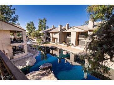 Complex features a serene pond with surrounding buildings and landscaping at 6550 N 47Th Ave # 235, Glendale, AZ 85301