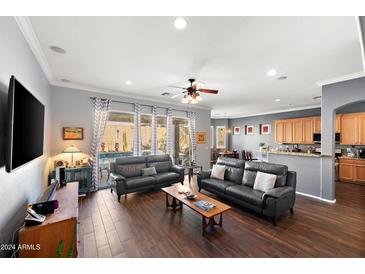 Spacious living room with dark leather sofas and hardwood floors at 2412 W Crimson Ter, Phoenix, AZ 85085
