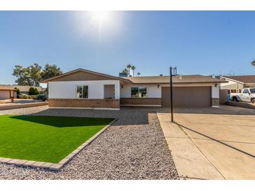 Single-story home with two-car garage and landscaped yard at 4302 N 80Th Ln, Phoenix, AZ 85033