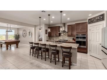 Open kitchen with granite island and breakfast bar at 26086 W Cat Balue Dr, Buckeye, AZ 85396