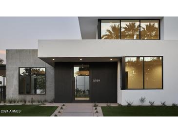 Modern home exterior with concrete and dark wood accents at 5939 E Orange Blossom Ln, Phoenix, AZ 85018