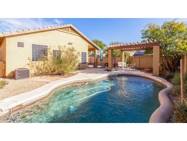 Relaxing kidney shaped pool with a pergola and patio furniture at 40710 N Boone Ln, Anthem, AZ 85086