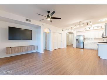 Open living room with wood floors, kitchen and bedroom access at 920 E Devonshire Ave # 2019, Phoenix, AZ 85014