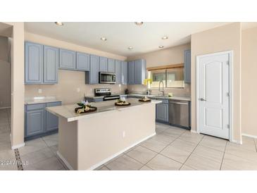 Modern kitchen with island, blue cabinets and marble countertops at 25575 W Lynne Ln, Buckeye, AZ 85326