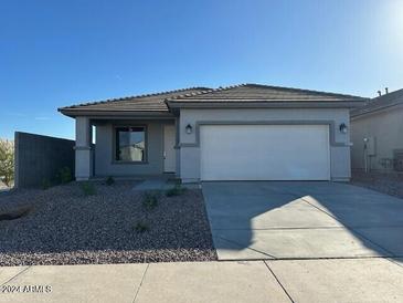 Single-story home with attached garage and desert landscaping at 16951 W Fetlock Trl, Surprise, AZ 85387