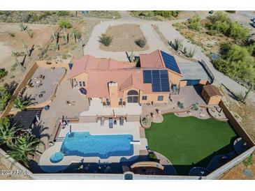 An aerial view of a home with a pool, solar panels, and desert landscaping at 38820 N 19Th Way, Phoenix, AZ 85086