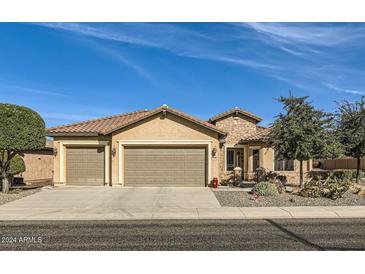 Beautiful desert landscape surrounds this single-story home with a three-car garage at 27046 W Yukon Dr, Buckeye, AZ 85396