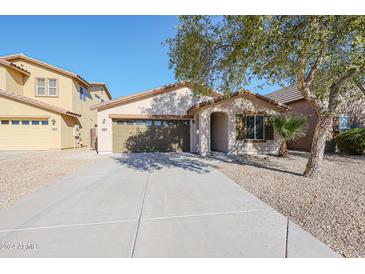 Single-story home with a two-car garage and landscaped front yard at 41208 W Bravo Dr, Maricopa, AZ 85138