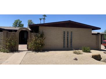 Inviting front yard with a brick walkway, arched entryway, and desert landscaping at 7131 E Cholla St, Scottsdale, AZ 85254