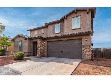 Two-story house with stone accents and a large garage at 4102 S 186Th Ave, Goodyear, AZ 85338