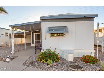 White mobile home with covered patio and landscaping at 44 S Hawes Rd # A15, Mesa, AZ 85208