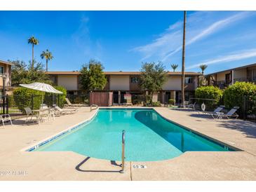 Inviting community pool with lounge chairs and patio umbrellas at 4701 N 68Th St # 248, Scottsdale, AZ 85251