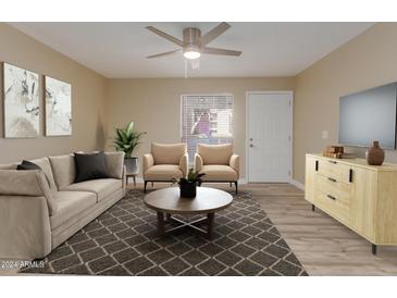 Bright living room featuring a neutral color palette, plush sofa, and two armchairs at 1340 N Recker Rd # 131, Mesa, AZ 85205