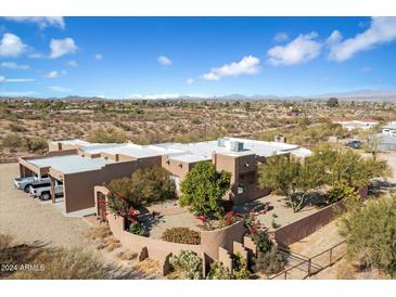 Aerial view showing a stucco home with a landscaped yard and mountain views at 501 S Saguaro Dr, Wickenburg, AZ 85390