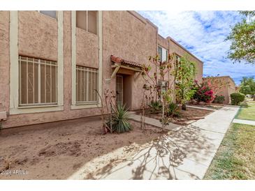 Front view of a light brown stucco condo with a walkway and landscaping at 8428 N 33Rd Dr, Phoenix, AZ 85051