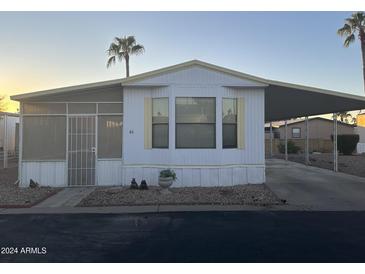 Single-wide manufactured home with carport and screened porch at 9427 E University Dr # 46, Mesa, AZ 85207