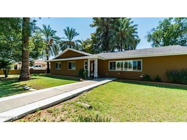 House exterior showcasing a walkway to the front door, and a well-manicured lawn at 1011 W Northern Ave, Phoenix, AZ 85021