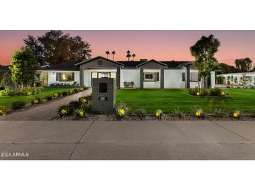 Stunning curb appeal featuring a remodeled mid-century modern home with a well-manicured lawn at 8701 E Highland Ave, Scottsdale, AZ 85251