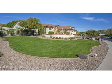 Landscaped front yard with a large grassy area and mature trees at 26702 N 97Th Ln, Peoria, AZ 85383