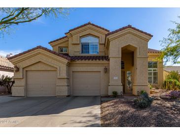 Two-story house with beige exterior, two-car garage, and landscaped front yard at 31013 N 41St Pl, Cave Creek, AZ 85331