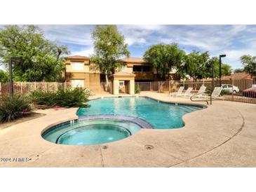 Community pool and spa with surrounding lounge chairs at 1445 E Broadway Rd # 120, Tempe, AZ 85282