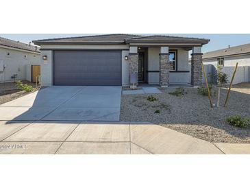 One-story house with gray exterior, two-car garage, and small front yard at 39995 W Bravo Dr, Maricopa, AZ 85138