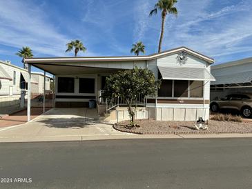 Single-wide manufactured home with carport and mature landscaping at 7750 E Broadway Rd # 149, Mesa, AZ 85208