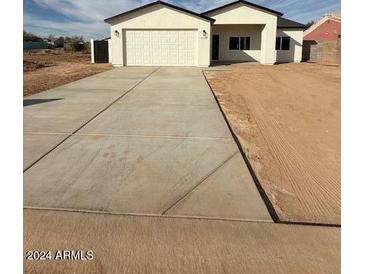 New construction home with a two-car garage and large driveway at 15200 S Capistrano Rd, Arizona City, AZ 85123