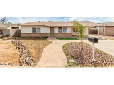 Ranch-style home with landscaped yard and paved driveway at 4511 W Palm Ln, Phoenix, AZ 85035