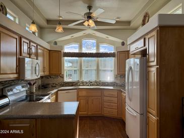 Bright kitchen with wood cabinets, granite countertops, and updated appliances at 7750 E Broadway Rd # 776, Mesa, AZ 85208