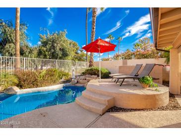 Inviting backyard oasis featuring a sparkling pool, ample deck space, and comfortable lounge chairs at 7634 W Julie Dr, Glendale, AZ 85308