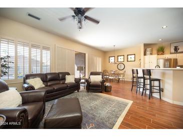 Spacious living room featuring a comfortable leather sofa and adjacent dining area at 401 W Locust Dr, Chandler, AZ 85248