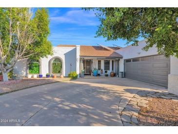 White stucco house with gray garage door, landscaping, and a paved driveway at 3401 N Dakota St, Chandler, AZ 85225