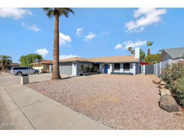 Updated single-level home with desert landscaping and a large driveway at 4832 W Caron St, Glendale, AZ 85302