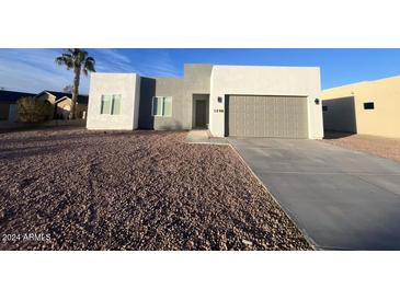 Modern stucco home with two-car garage and desert landscaping at 1298 W Calle Tuberia --, Casa Grande, AZ 85194