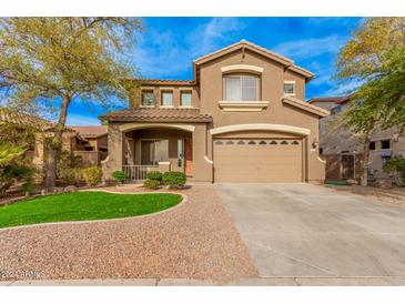 Two-story house with a large front yard, two-car garage, and neutral color scheme at 322 E Caribbean Dr, Casa Grande, AZ 85122